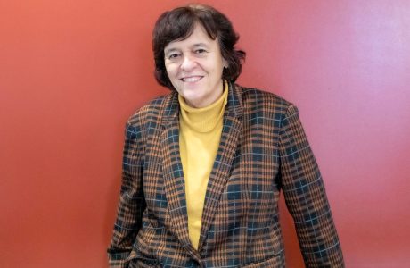 woman stands in front of red background