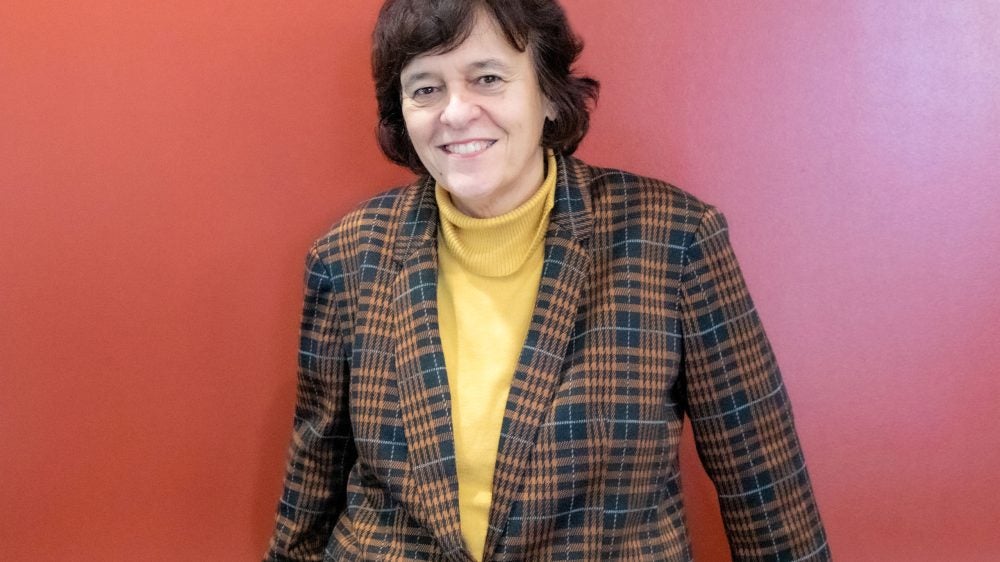 woman stands in front of red background