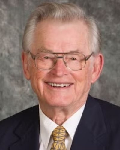 Person with glasses, wearing suit and tie