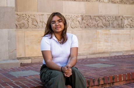 young woman sits on steps outside a building