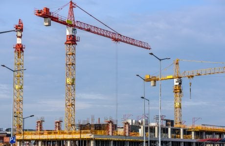 Three cranes on a construction site|