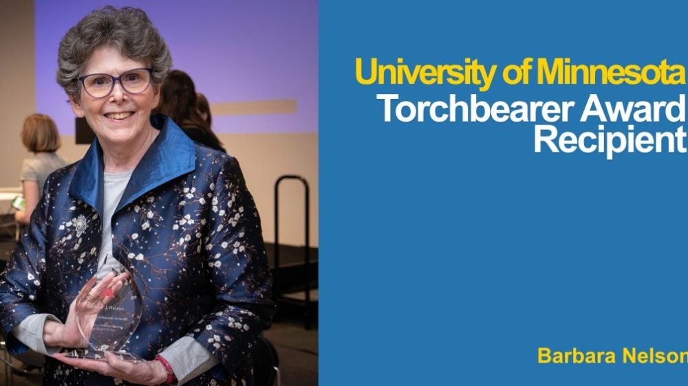 Photo of Barbara Nelson holding her Torchbearer Award at the ceremony|