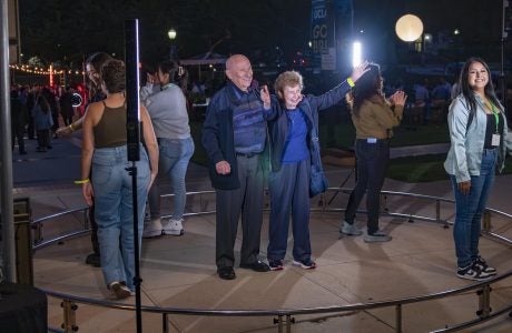 People standing in circle on outdoor stage