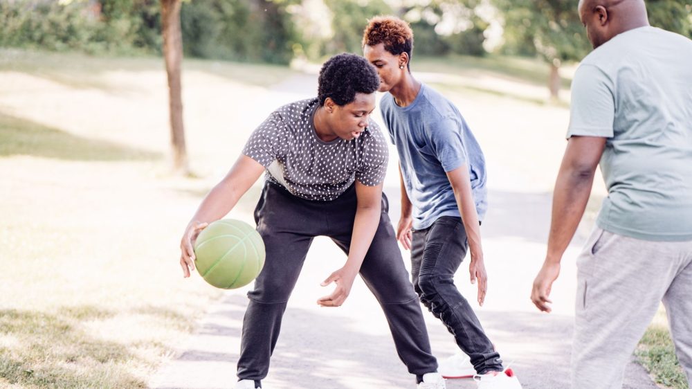 three boys are playing basketball|Young man sitting on the couch with a therapist.