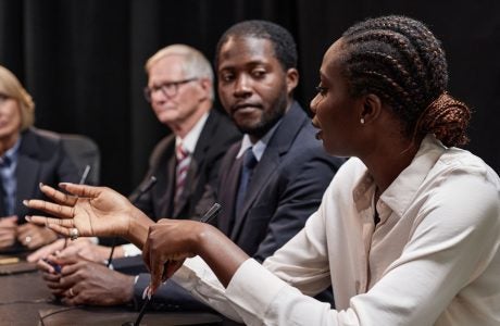 Black Woman Posing Question to Colleague during Committee Session at Political Meeting|Police officer and driver.