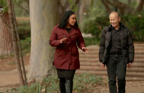 woman in maroon coat and man in black coat walking outdoors