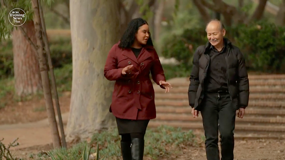 woman in maroon coat and man in black coat walking outdoors