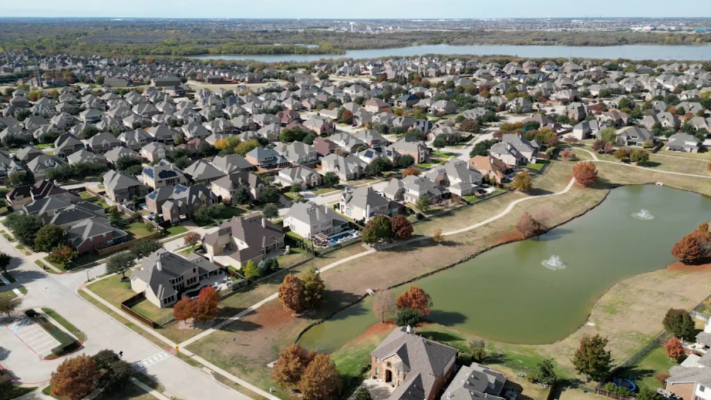 overhead shot of housing development near manmade lakes