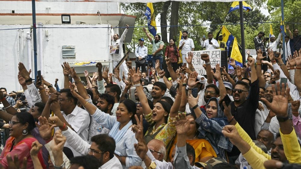 people with arms raised at a rally in India