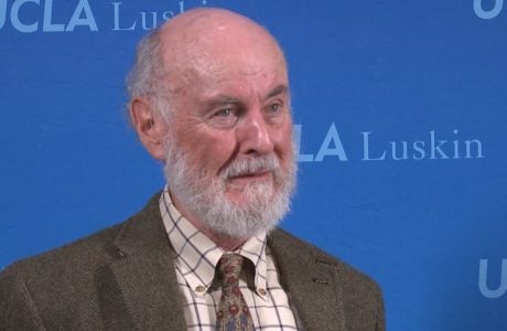 man with gray beard against blue background