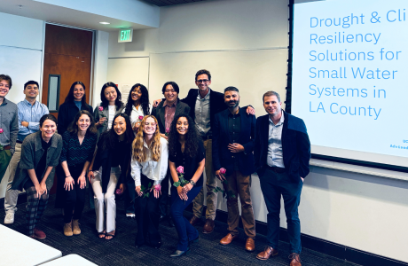 Group of masters in urban and regional planning students stand with their advisors on their capstone presentation day.|
