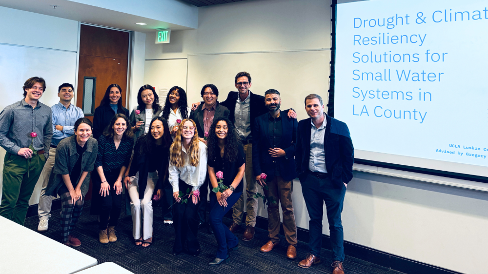 Group of masters in urban and regional planning students stand with their advisors on their capstone presentation day.|