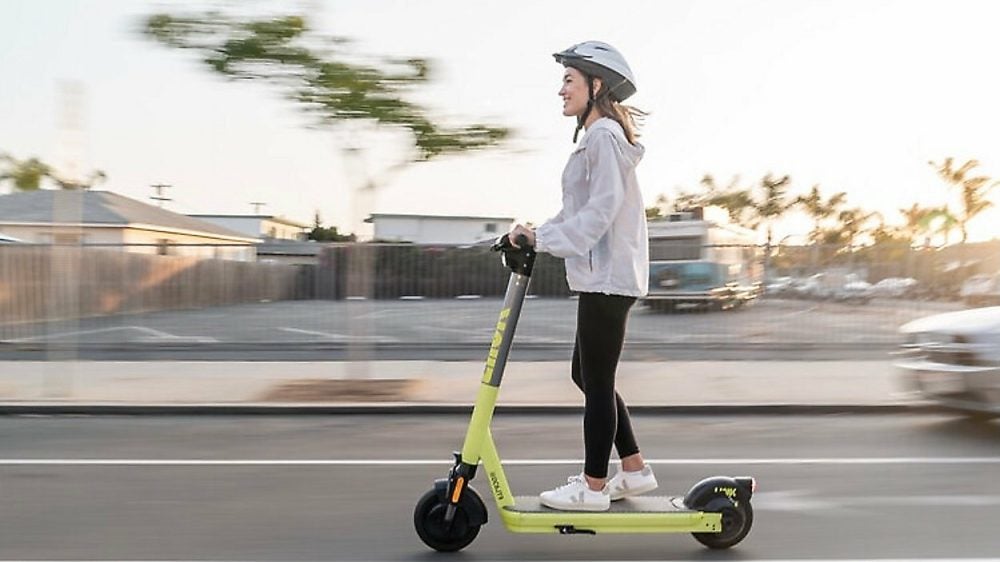 stock image shows a young woman on a scooter
