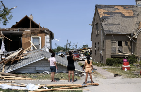 residents in front of damaged home with roof ripped off