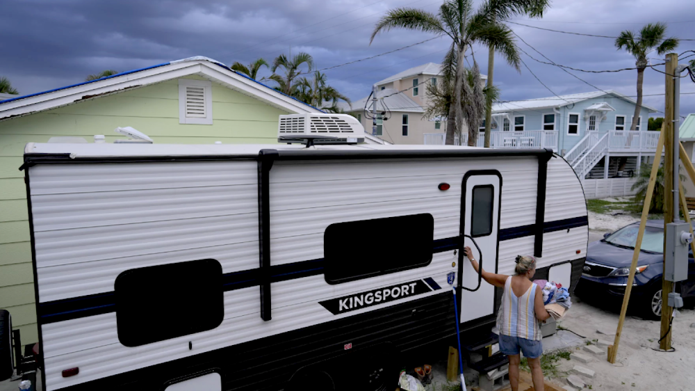 woman entering RV under threatening skies