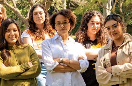 young people with arms folded pose outside