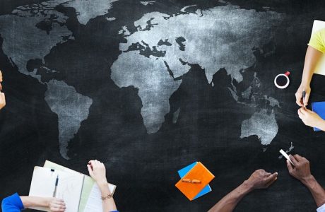 people studying around map of world|young woman with glasses