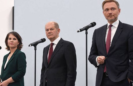 woman and two men on stage with microphones