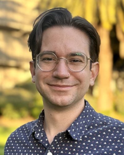 person in glasses, smiling, outdoors
