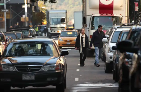people and cars on busy street