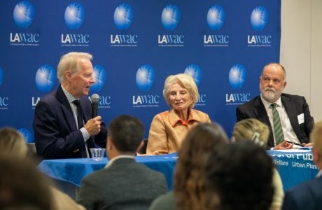 Two men and one woman seated at panel discussion