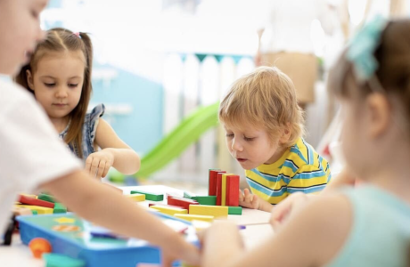 Children at a table, playing with colorful building blocks