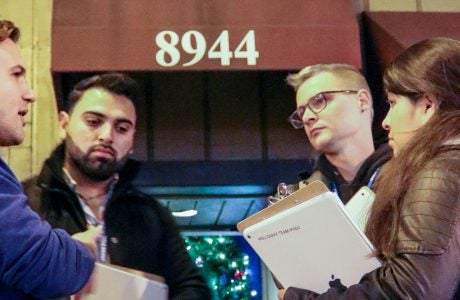 UCLA Luskin Assistant Professor Ian Holloway discusses survey options with a team of student canvassers outside a venue in West Hollywood in December 2016. Photo by Les Dunseith