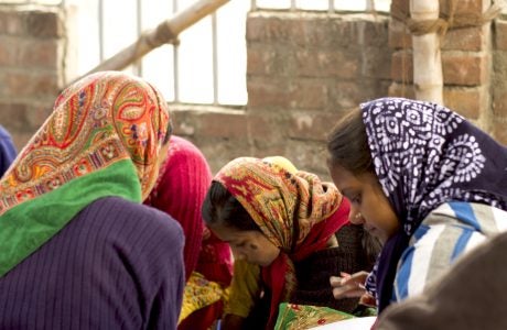 Girls in Indian village school study in a cirlcle, wearing head scarves