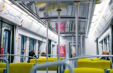 Interior shot of a Paris public transit train with some passengers seated.
