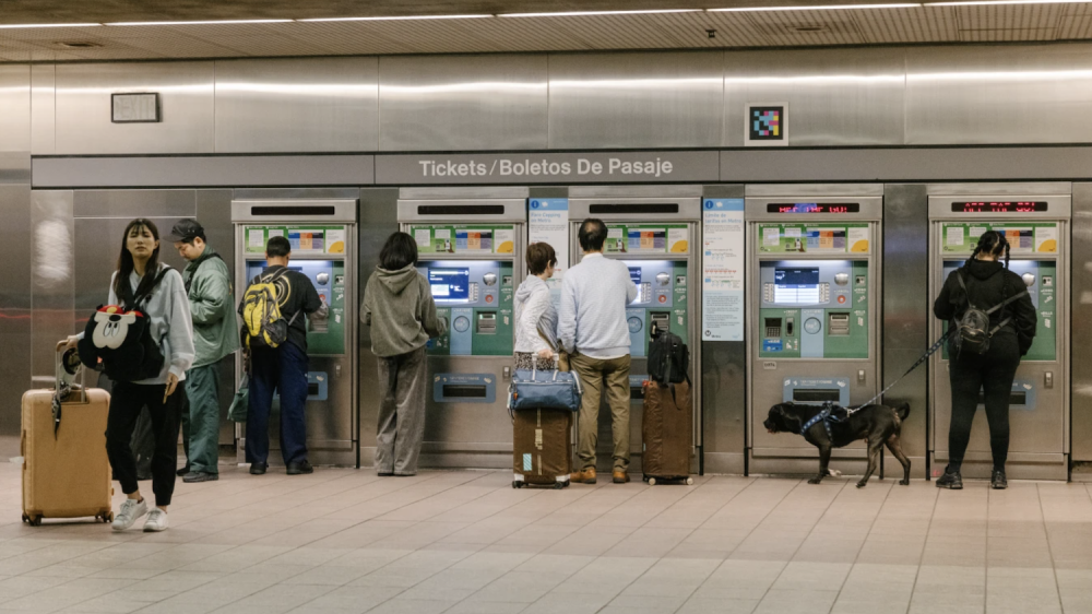 Transit riders purchase tickets at fare machines