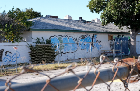 graffiti on building behind chain-link fence