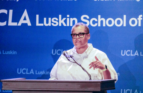 woman with glasses and white shirt at podium