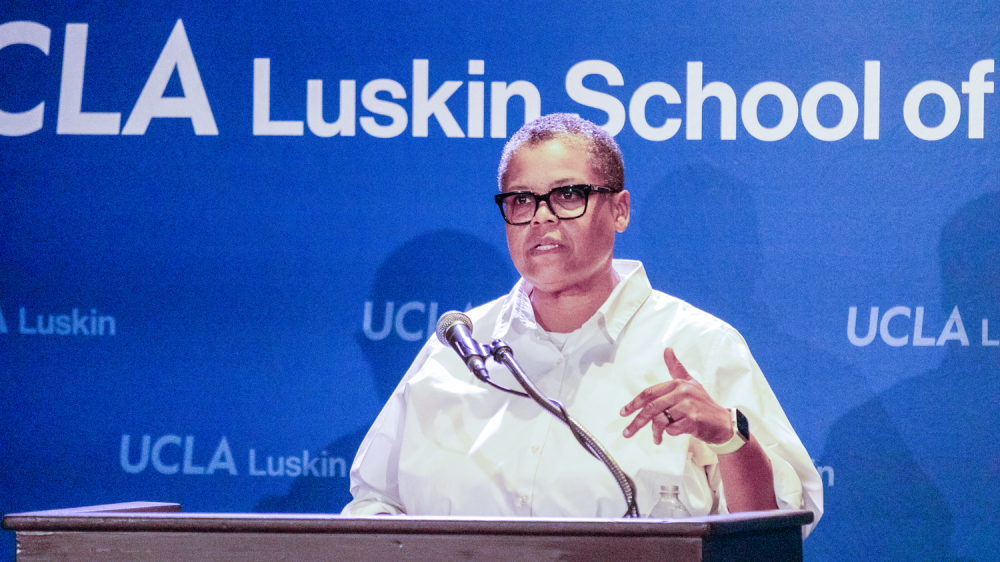 woman with glasses and white shirt at podium