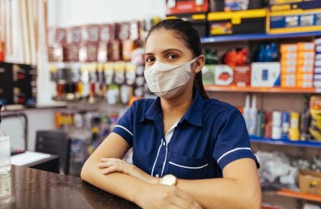 Young woman wearing face mask working in hardware store