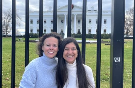 Two women in front of White House fence
