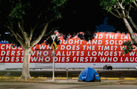 blue tent in front of red and white mural