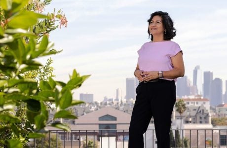 Woman in pink top with L.A. skyline in background