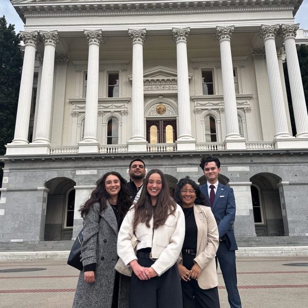 Group of 5 public policy students in front of the Sacramento capitol building