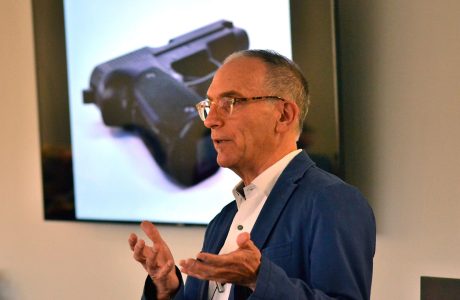Professor Mark Kaplan speaks in class about firearm suicides and behind him is an image of a gun on the projector.