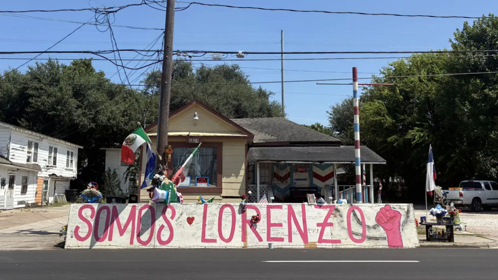 memorial in front of house with sign saying "Somos Lorenzo"