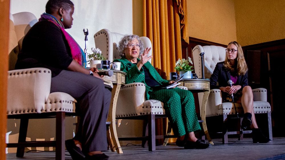 Three women seated on a stage