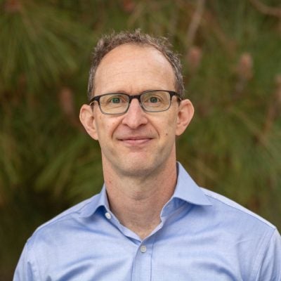 |portrait image of man with glasses and blue shirt