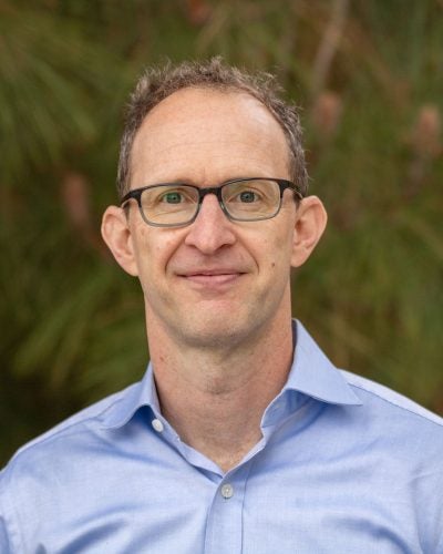 |portrait image of man with glasses and blue shirt