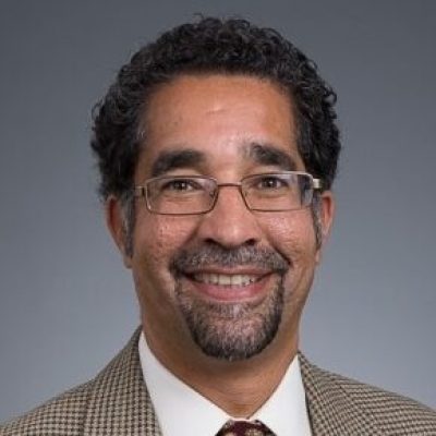 headshot of man with glasses in suit