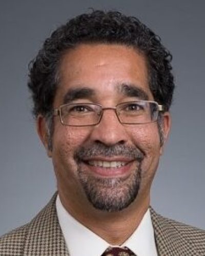 headshot of man with glasses in suit