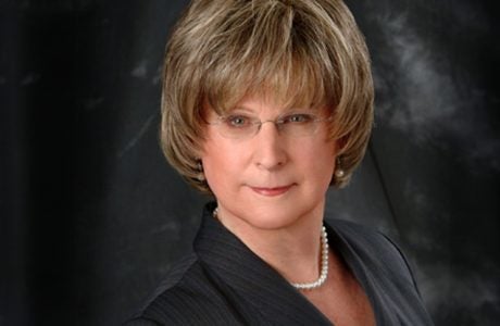 portrait photo of Michelle Dennis wearing glasses and a dark top