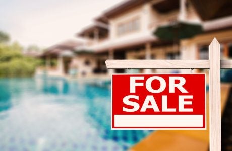 Backyard of a house with a swimming pool with "For Sale" sign