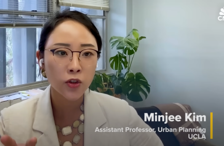 Dr. Minjee Kim sits in her office being interviewed via Zoom for a CNBC feature on the rise of gated communities in the U.S.