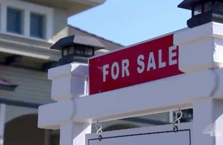 "For Sale" sign in front of house