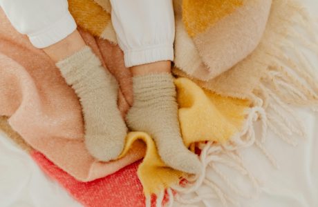 fuzzy socks on feet set against blanket